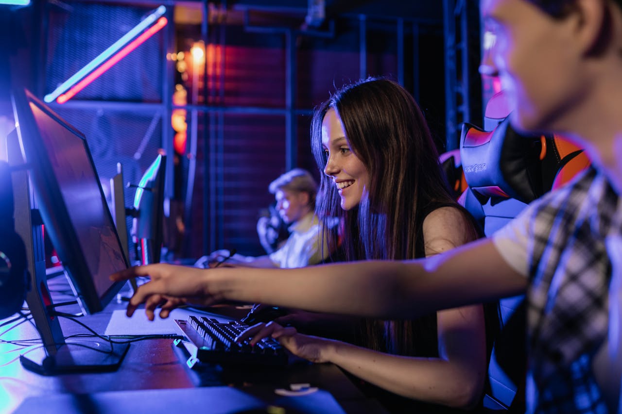 story-01 Group of teenagers happily engaged in gaming at a computer setup indoors.